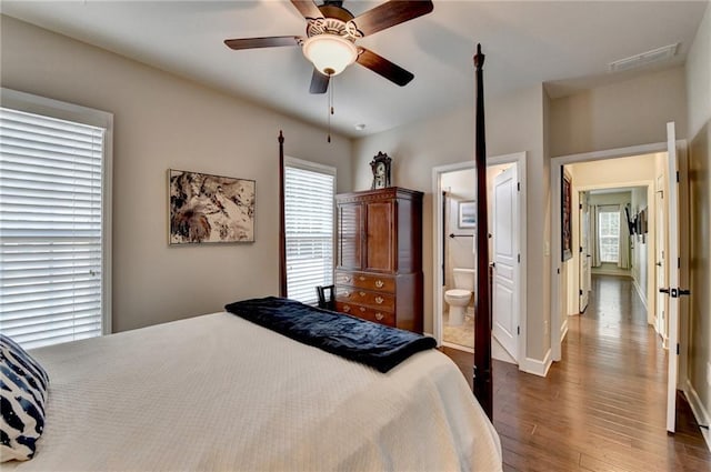 bedroom with baseboards, visible vents, a ceiling fan, connected bathroom, and wood finished floors