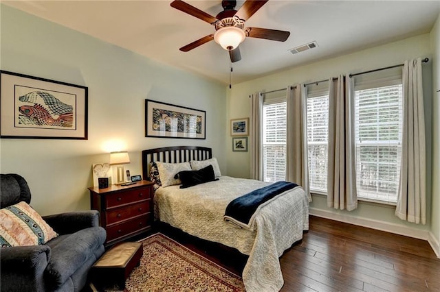 bedroom with dark wood-style flooring, visible vents, ceiling fan, and baseboards