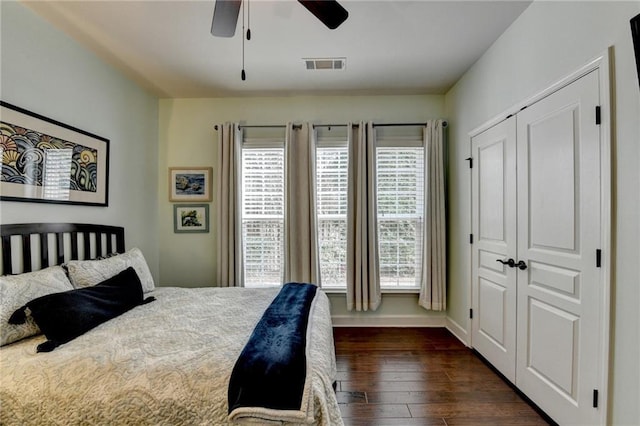 bedroom with multiple windows, visible vents, dark wood finished floors, and a ceiling fan