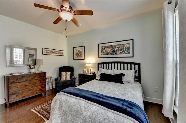 bedroom featuring ceiling fan, baseboards, and wood finished floors