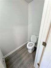 bathroom featuring wood-type flooring and toilet