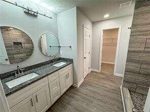 bathroom featuring vanity, wood-type flooring, and walk in shower