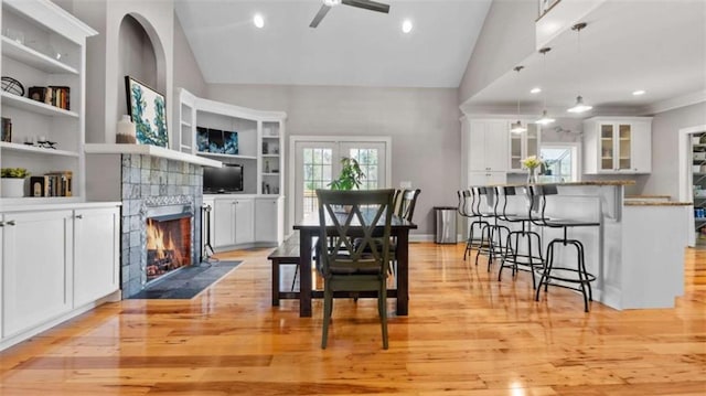 745 Pleasant Valley Rd, Silver Creek, GA 30173 - dining area with a ceiling fan, light wood finished floors, a fireplace with flush hearth, built in features, and high vaulted ceiling