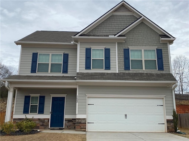 craftsman-style house with stone siding, an attached garage, driveway, and a shingled roof