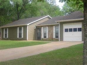 ranch-style home with a garage and a front lawn