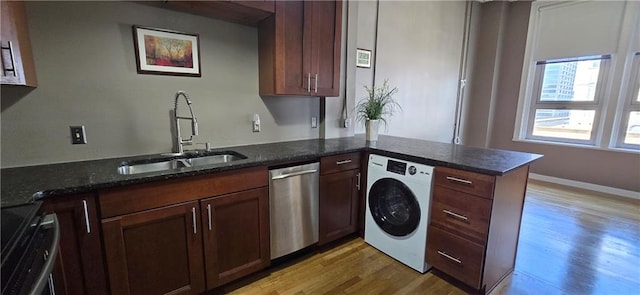 kitchen featuring washer / dryer, stainless steel dishwasher, a sink, light wood finished floors, and electric range oven