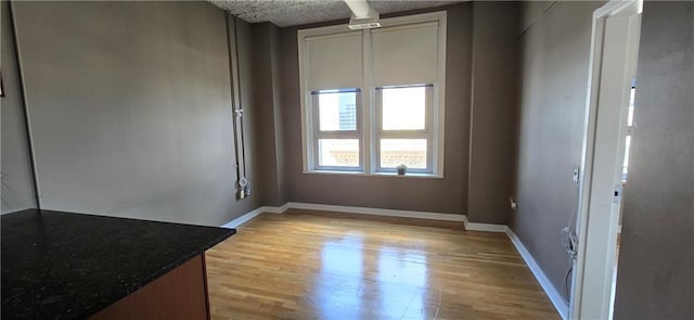 spare room featuring light wood-style flooring and baseboards