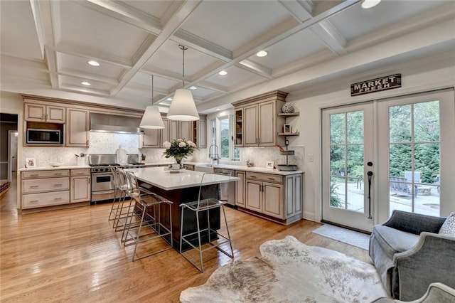 5475 Trowbridge Dr, Dunwoody, GA 30338 - kitchen with a sink, open shelves, a breakfast bar area, wall chimney range hood, and appliances with stainless steel finishes
