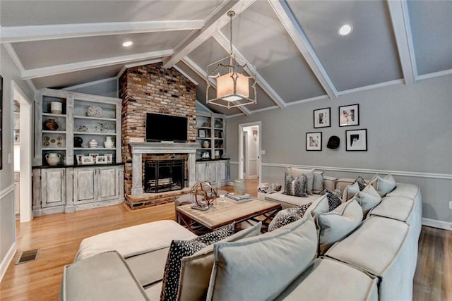 5475 Trowbridge Dr, Dunwoody, GA 30338 - living room featuring visible vents, an inviting chandelier, a brick fireplace, wood finished floors, and vaulted ceiling with beams