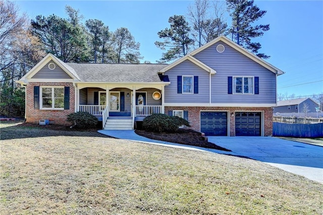 split level home featuring a porch, a garage, brick siding, concrete driveway, and a front lawn