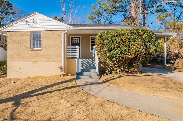 view of front of house featuring a front lawn, a carport, and a porch