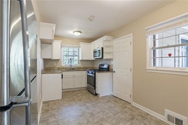 kitchen featuring sink, white cabinetry, appliances with stainless steel finishes, and dark stone countertops