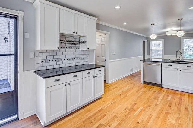 kitchen featuring a sink, dark countertops, crown molding, and dishwasher