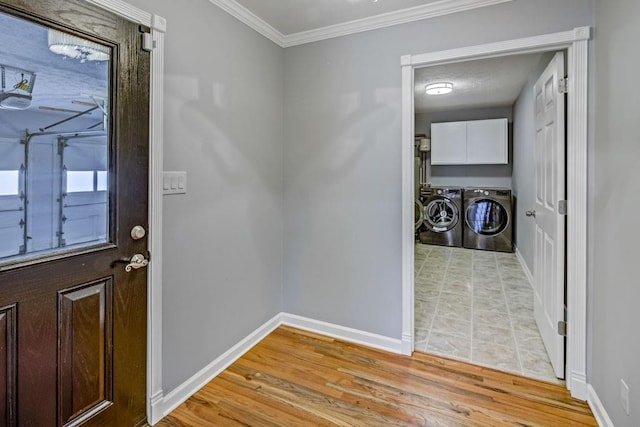 entrance foyer with baseboards, ornamental molding, light wood-style flooring, and washer and dryer