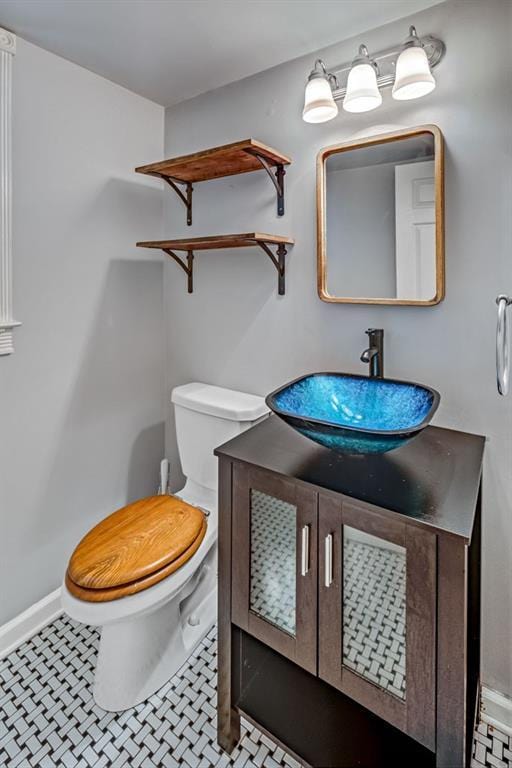 half bath featuring vanity and toilet