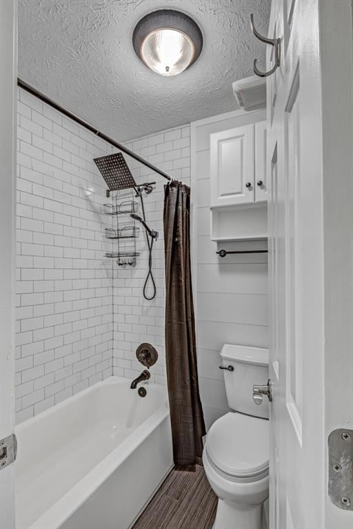 bathroom featuring toilet, a textured ceiling, and shower / tub combo with curtain