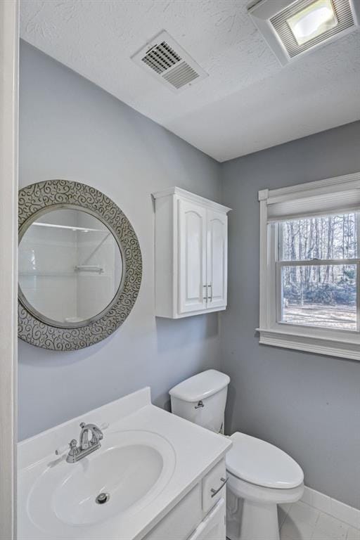 bathroom featuring vanity, baseboards, toilet, and visible vents