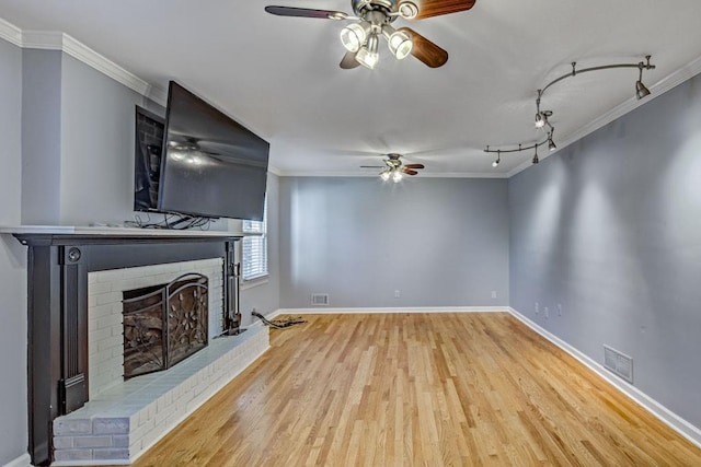 unfurnished living room featuring a ceiling fan, rail lighting, visible vents, and wood finished floors