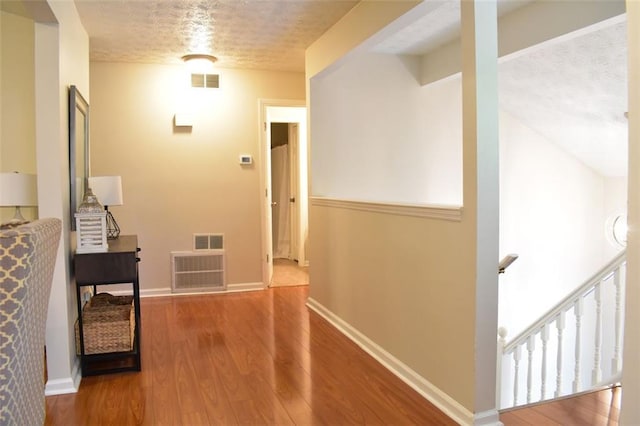1676 Northridge Dr, Morrow, GA 30260 - hall featuring wood finished floors, a textured ceiling, and visible vents