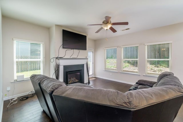 living room with dark hardwood / wood-style floors, ceiling fan, and a healthy amount of sunlight