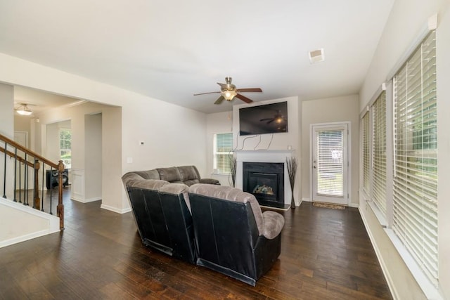 living room with ceiling fan and dark wood-type flooring