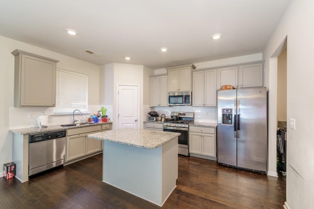 kitchen featuring dark wood-type flooring, sink, a center island, and stainless steel appliances