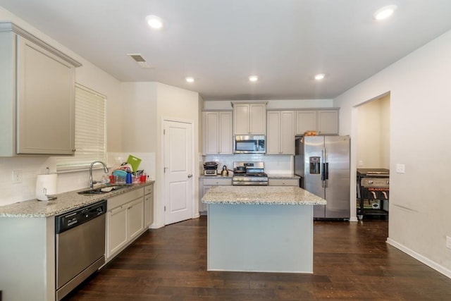 kitchen featuring a kitchen island, dark hardwood / wood-style flooring, sink, and appliances with stainless steel finishes
