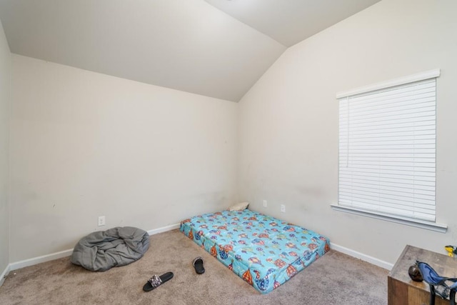 bedroom featuring light colored carpet and vaulted ceiling