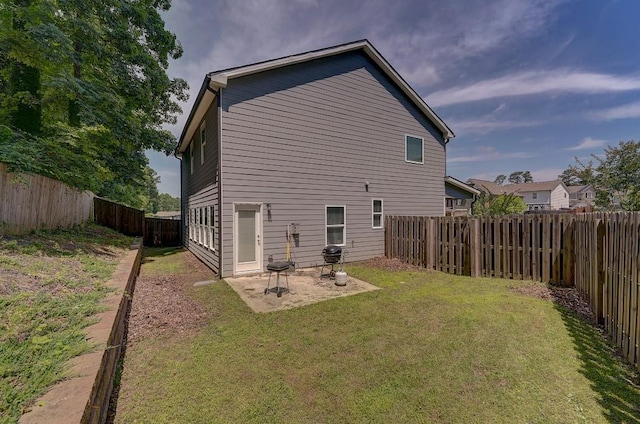 back of house featuring a patio area and a yard