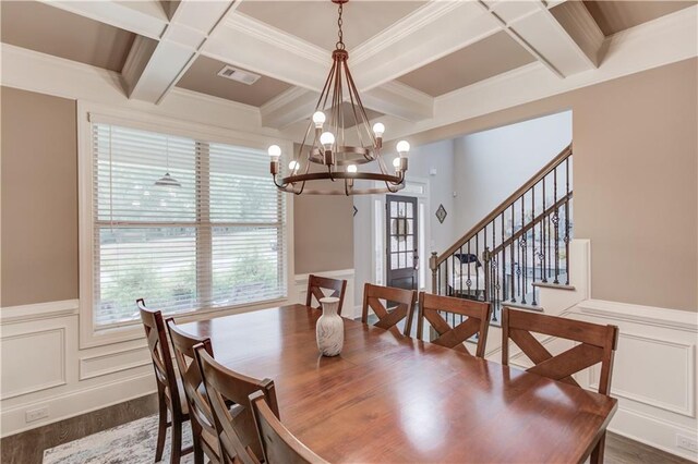 dining space featuring beamed ceiling, an inviting chandelier, crown molding, coffered ceiling, and dark hardwood / wood-style flooring