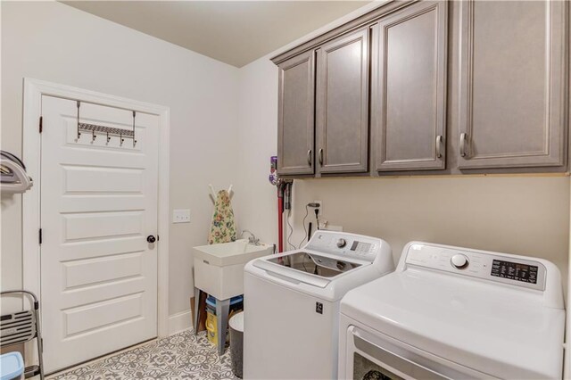 laundry area featuring cabinets, sink, and separate washer and dryer