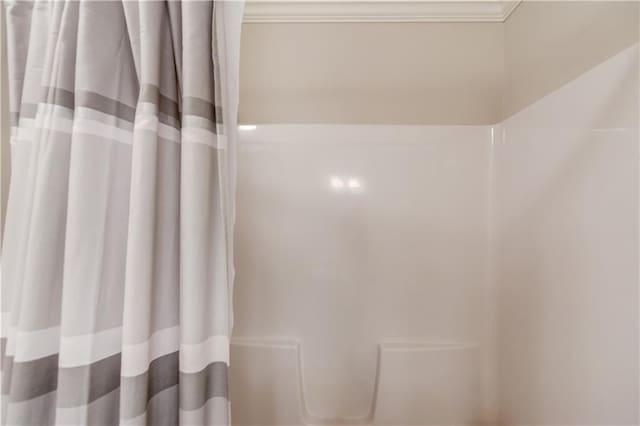 bathroom featuring walk in shower and ornamental molding