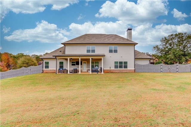 rear view of property with a yard and a patio area