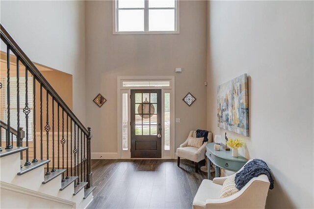 entrance foyer featuring a towering ceiling and dark hardwood / wood-style floors