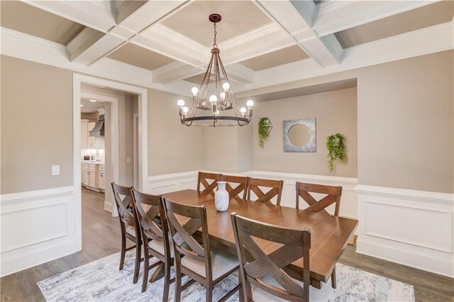 dining area with dark hardwood / wood-style flooring, coffered ceiling, an inviting chandelier, and beamed ceiling