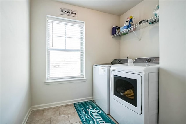 laundry area with washing machine and dryer, plenty of natural light, and baseboards