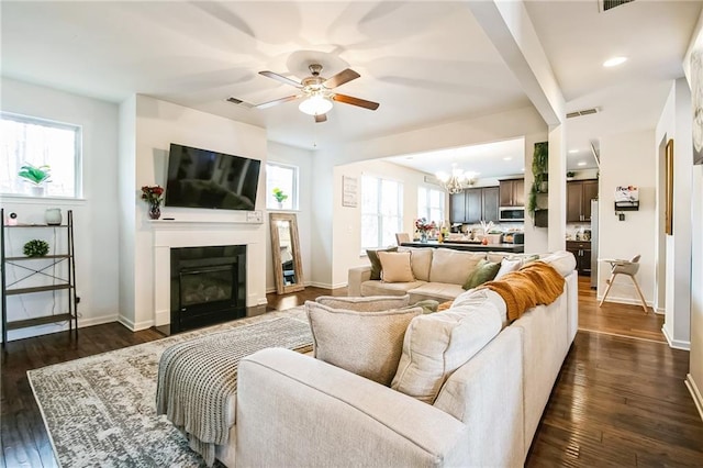 living room featuring a chandelier, plenty of natural light, ceiling fan, a glass covered fireplace, and recessed lighting