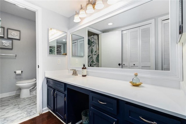 full bath featuring vanity, wood finished floors, baseboards, a closet, and toilet