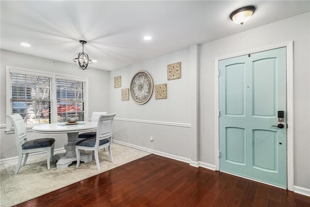 dining area with hardwood / wood-style floors, baseboards, and a chandelier