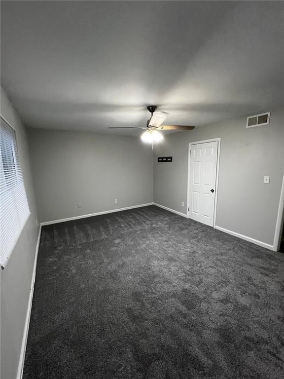 carpeted spare room featuring ceiling fan