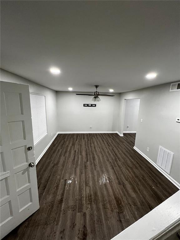 basement with ceiling fan and dark hardwood / wood-style flooring