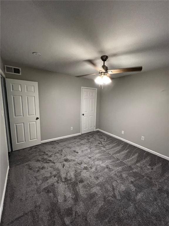 unfurnished bedroom featuring dark colored carpet and ceiling fan