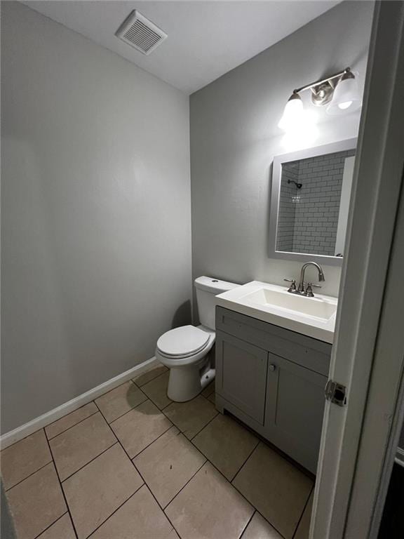 bathroom featuring tile patterned flooring, vanity, and toilet