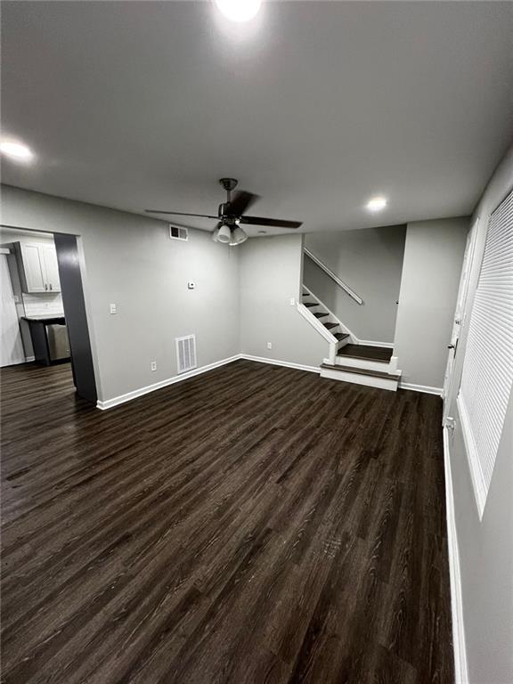 unfurnished living room featuring dark hardwood / wood-style floors and ceiling fan