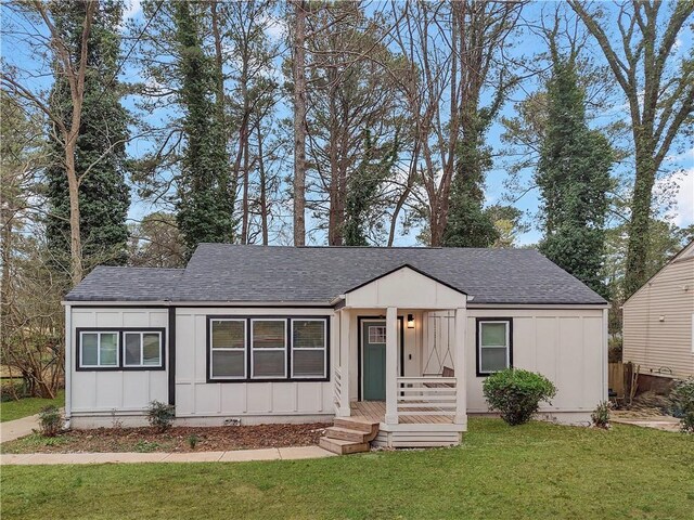view of front of property featuring crawl space, board and batten siding, a front yard, and a shingled roof
