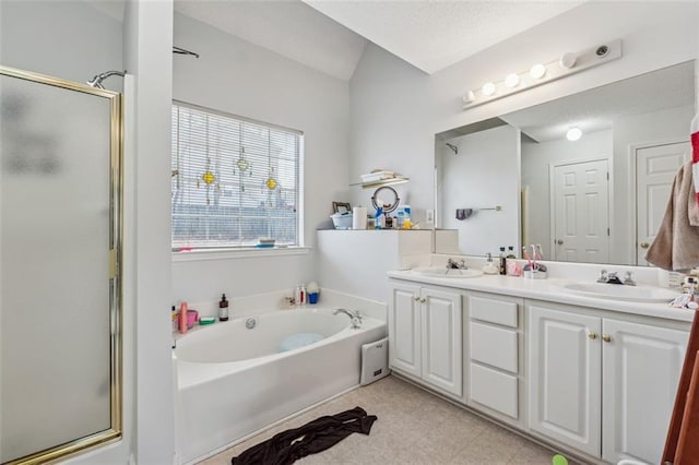 bathroom with a bath, a stall shower, double vanity, and a sink