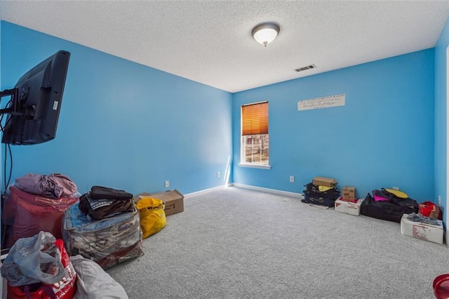 recreation room with baseboards, visible vents, a textured ceiling, and carpet