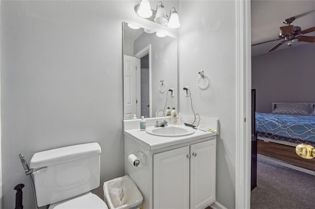 ensuite bathroom with connected bathroom, toilet, vanity, and a ceiling fan