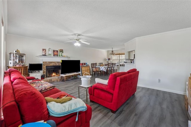 living room with a textured ceiling, wood finished floors, a stone fireplace, baseboards, and ceiling fan