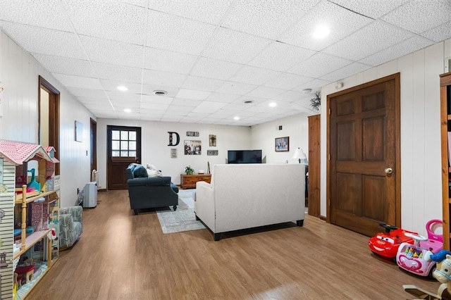 living room with a paneled ceiling and light hardwood / wood-style flooring